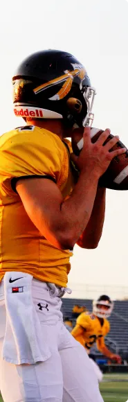 football player throwing ball with used football equipment