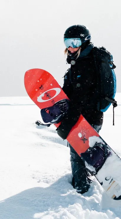 Snowboarder standing in snow with quality used sports equipment