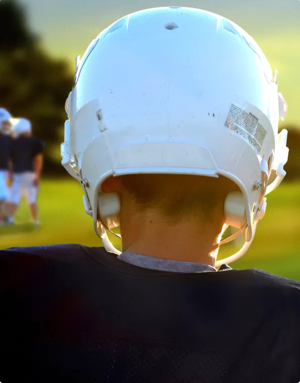 young football player with used football helmet